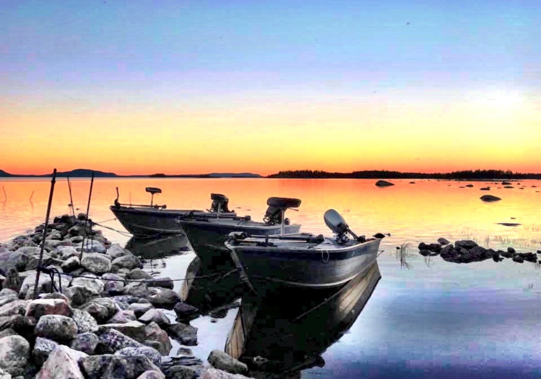 Boats on a Lapland lake near Wild Lake Lodge at sunset